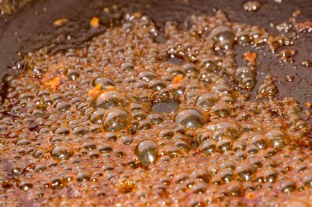 Téléchargez les photos : "Vue détaillée de la caramélisation du sucre dans une poêle
 " - en image libre de droit
