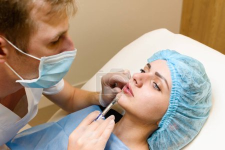 Foto de Aumento de labios rejuvenecimiento de inyecciones faciales 'procedimiento para chica atractiva. Cirugía plástica en clínica médica privada. - Imagen libre de derechos