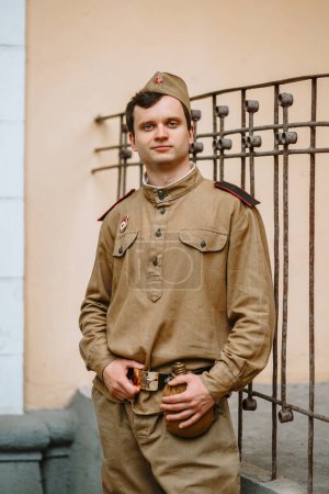 Foto de "A man in a Soviet world war II uniform stands at the yellow wall" - Imagen libre de derechos
