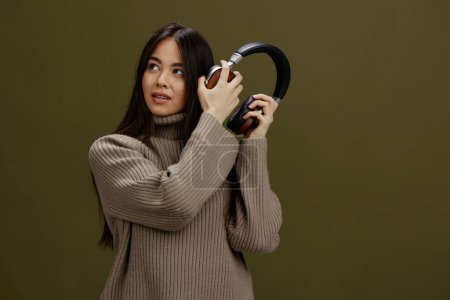 Téléchargez les photos : "portrait femme dans des écouteurs écoutant de la musique. Fond vert" - en image libre de droit
