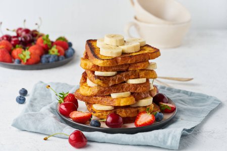 Foto de "Tostadas francesas con bayas y plátano, desayuno brioche, fondo blanco, primer plano" - Imagen libre de derechos