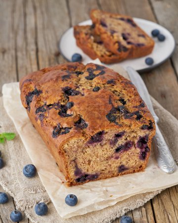Photo for "Banana bread on old wooden rustic table, slice of cake with banana, side view, vertical" - Royalty Free Image