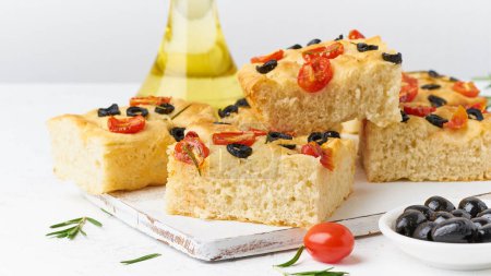 Photo for "Focaccia with tomatoes, olives and rosemary, side view. Traditional Italian flat bread" - Royalty Free Image