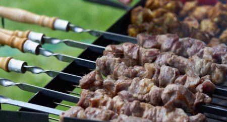 Foto de Barbacoa shashlik kebab con winglets en chargrill semiacabado en brochetas vista lateral primer plano - Imagen libre de derechos