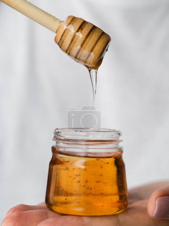 Photo for "honey dripping from dipper on background, close up - Royalty Free Image