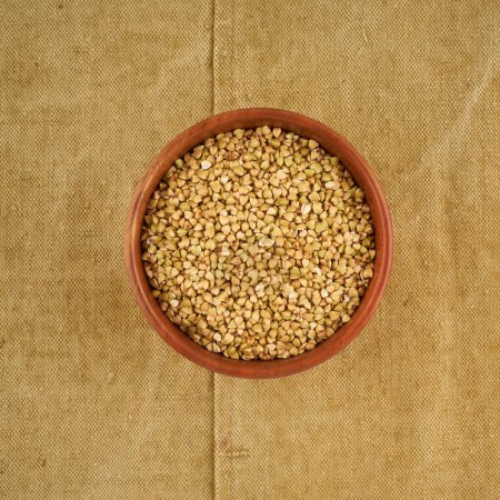 Photo for "green buckwheat in wooden bowl on old linen napkin, gluten free wholegrain, fodmap diet" - Royalty Free Image