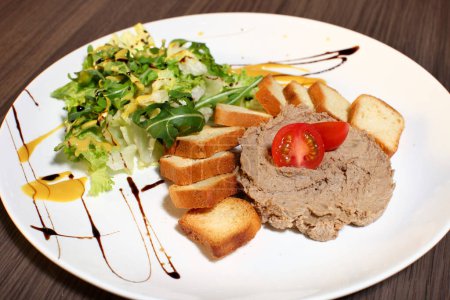 Photo for "Slice of toasted bread and liver pate on white plate" - Royalty Free Image