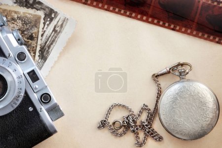 Foto de "Pila de papeles viejos, reloj y cámara fotográfica" - Imagen libre de derechos