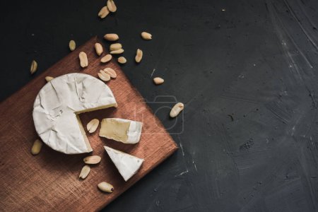 Photo for "cheese camembert with mold and nuts on wooden board" - Royalty Free Image