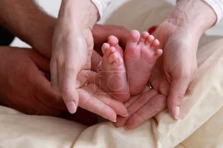 Téléchargez les photos : "Pieds de bébé dans les mains de la mère avec soin
" - en image libre de droit