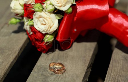 Téléchargez les photos : "vue du haut du bouquet de luxe de fleurs rouges et blanches vue du haut avec arc rouge le jour du mariage vacances.Anneaux" - en image libre de droit