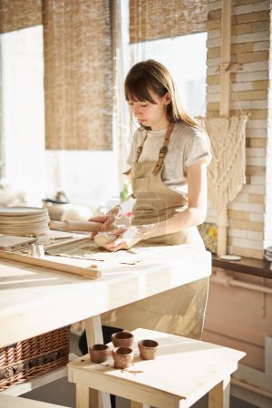 Téléchargez les photos : Femme freelance, affaires, passe temps. Femme faisant des poteries en céramique - en image libre de droit