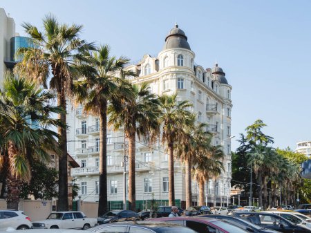 Téléchargez les photos : "SOCHI, RUSSIA - May 27, 2021. Facade of apartment hotel Matisse. Beautiful building with palm trees alley at sunny day." - en image libre de droit