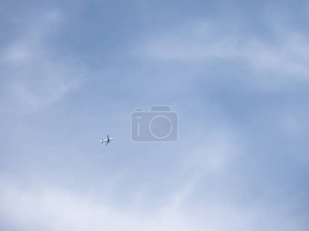 Photo for "Airplane is flying in clear blue sky. Aircraft in flight in good weather. Minimalism." - Royalty Free Image