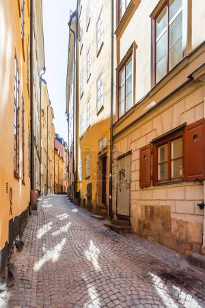 Photo for "STOCKHOLM, SWEDEN - July 06, 2017. Narrow streets in historic part of town. Old fashioned buildings in Gamla stan." - Royalty Free Image