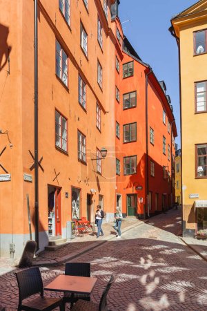 Téléchargez les photos : "STOCKHOLM, SUÈDE - 6 juillet 2017. Les touristes marchent dans des rues étroites dans la partie historique de la ville. Bâtiments à l'ancienne au Gamla stan." - en image libre de droit