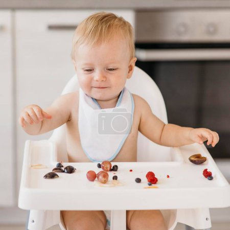 Photo for Smiley cute baby eating alone - Royalty Free Image