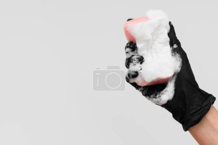 Foto de Mano con guante celebración esponja con espuma copia ritmo - Imagen libre de derechos