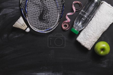 Photo for Composition with badminton racket water bottle apple - Royalty Free Image