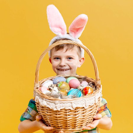 Téléchargez les photos : Petit garçon tenant panier avec des œufs peints - en image libre de droit
