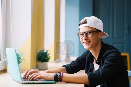 Photo for Smiling youngster with gadget classroom - Royalty Free Image