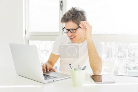 Téléchargez les photos : Homme heureux regardant écran d'ordinateur portable - en image libre de droit