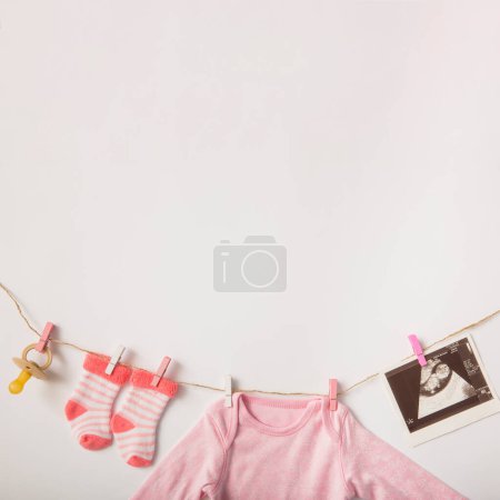 Téléchargez les photos : "sucette sonographie image chaussettes bébé vêtements suspendus corde à linge fond blanc" - en image libre de droit
