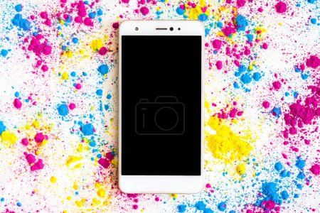 Photo for "holi color powder around smartphone with black screen display" - Royalty Free Image
