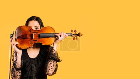Photo for "girl hiding violin on background, close up - Royalty Free Image