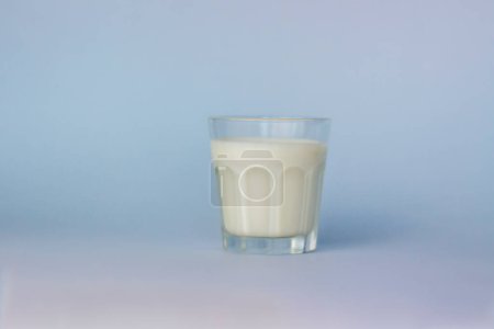 Téléchargez les photos : "Un verre de lait blanc, mis en valeur sur un fond bleu, gros plan. " - en image libre de droit