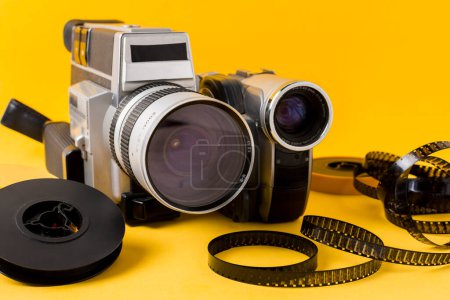 Téléchargez les photos : "film de caméra moderne bobine bandes de film fond jaune" - en image libre de droit