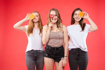 Téléchargez les photos : Trois filles heureuses avec des oranges et des bonbons doux
. - en image libre de droit