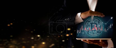 Photo for "Hands of businessman holding tablet and show bitcoin coin digital graphic. Volatile business graph on network, Financial, Stock market, Cryptocurrency and investment. New Virtual money concept" - Royalty Free Image