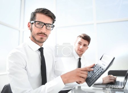 Téléchargez les photos : "Male arm in suit hold calculator showing in office" - en image libre de droit