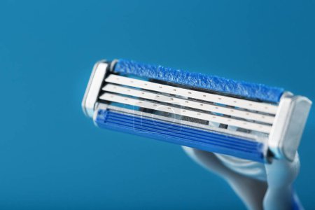 Téléchargez les photos : "Shaving machine with three blades on a blue background close-up free space" - en image libre de droit