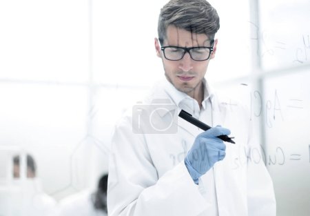 Photo for Scientist making notes on the glass Board at the time of the experiment - Royalty Free Image