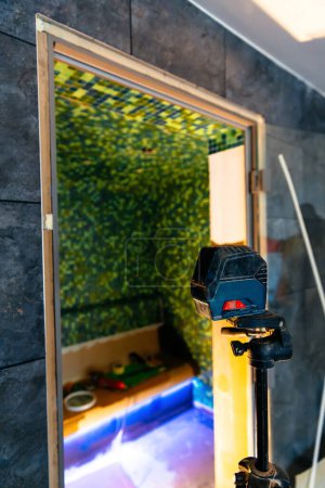 Photo for "Laser level in applying mosaic tiles on walls" - Royalty Free Image
