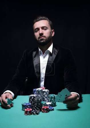 Photo for "Happy poker player winning and holding a pair of aces" - Royalty Free Image