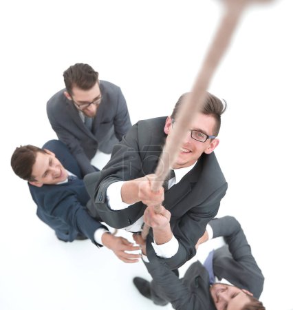 Téléchargez les photos : Équipe d'affaires aidant le leader à grimper la corde - en image libre de droit