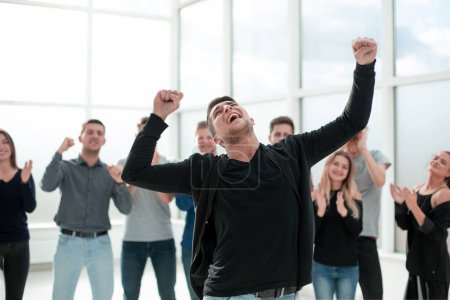 Téléchargez les photos : Jeune entrepreneur debout devant l'équipe d'affaires applaudissant - en image libre de droit