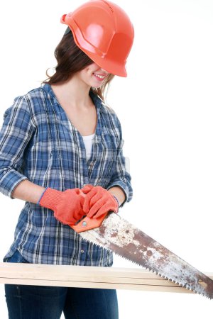Photo for "Young female builder in helmet cutting wooden boards" - Royalty Free Image