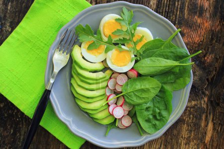 Photo for "Breakfast salad with radishes, boiled egg and mix lettuce leaves,spinach. Food background. Top view" - Royalty Free Image