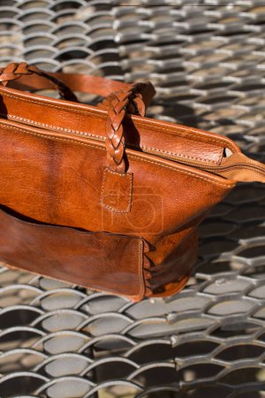Téléchargez les photos : "close-up photo of orange leather bag on a metal texture background" - en image libre de droit