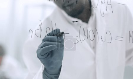 Téléchargez les photos : "scientifique écrivant la formule chimique sur un panneau de verre" - en image libre de droit