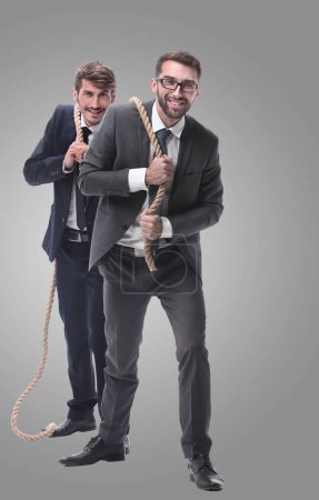 Photo for Two businessmen pulling a long rope. - Royalty Free Image