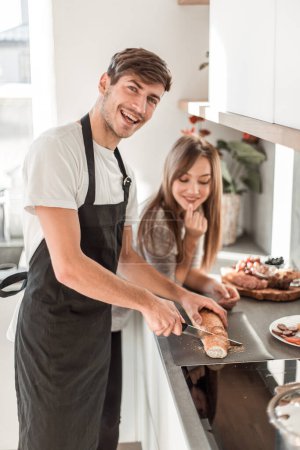 Photo for "happy young couple with food in their new kitchen - Royalty Free Image
