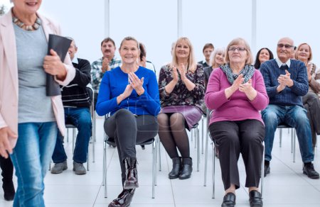 Téléchargez les photos : "un groupe de personnes âgées applaudit dans la salle de conférence" - en image libre de droit