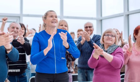 Photo for "a group of elderly people are sitting in a circle clapping their hands - Royalty Free Image