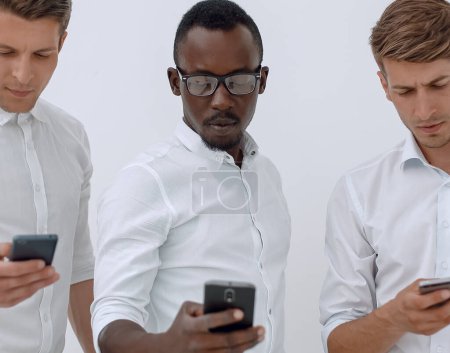 Téléchargez les photos : Groupe de jeunes hommes d'affaires multiethniques utilisant des téléphones mobiles - en image libre de droit