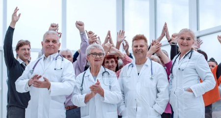 Téléchargez les photos : Médecins et un groupe de personnes âgées en pleine croissance à l'intérieur mains en l'air - en image libre de droit